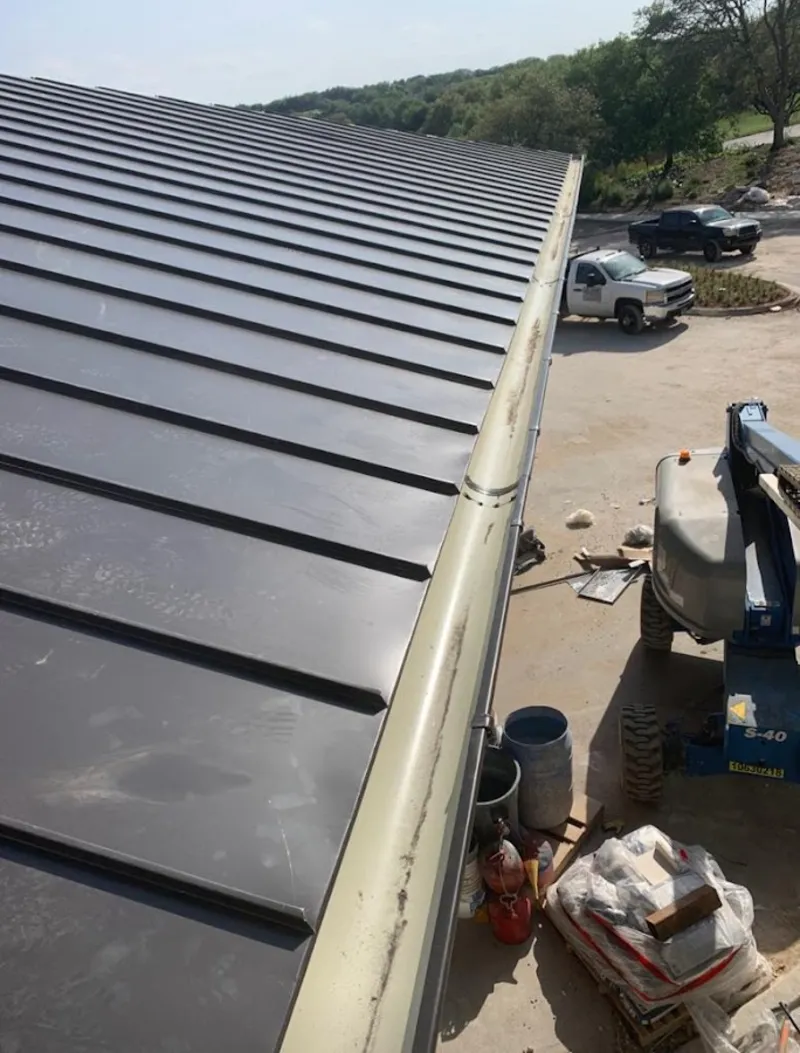 Standing seam panel and gutter detail on a metal roofing jobsite in Savannah